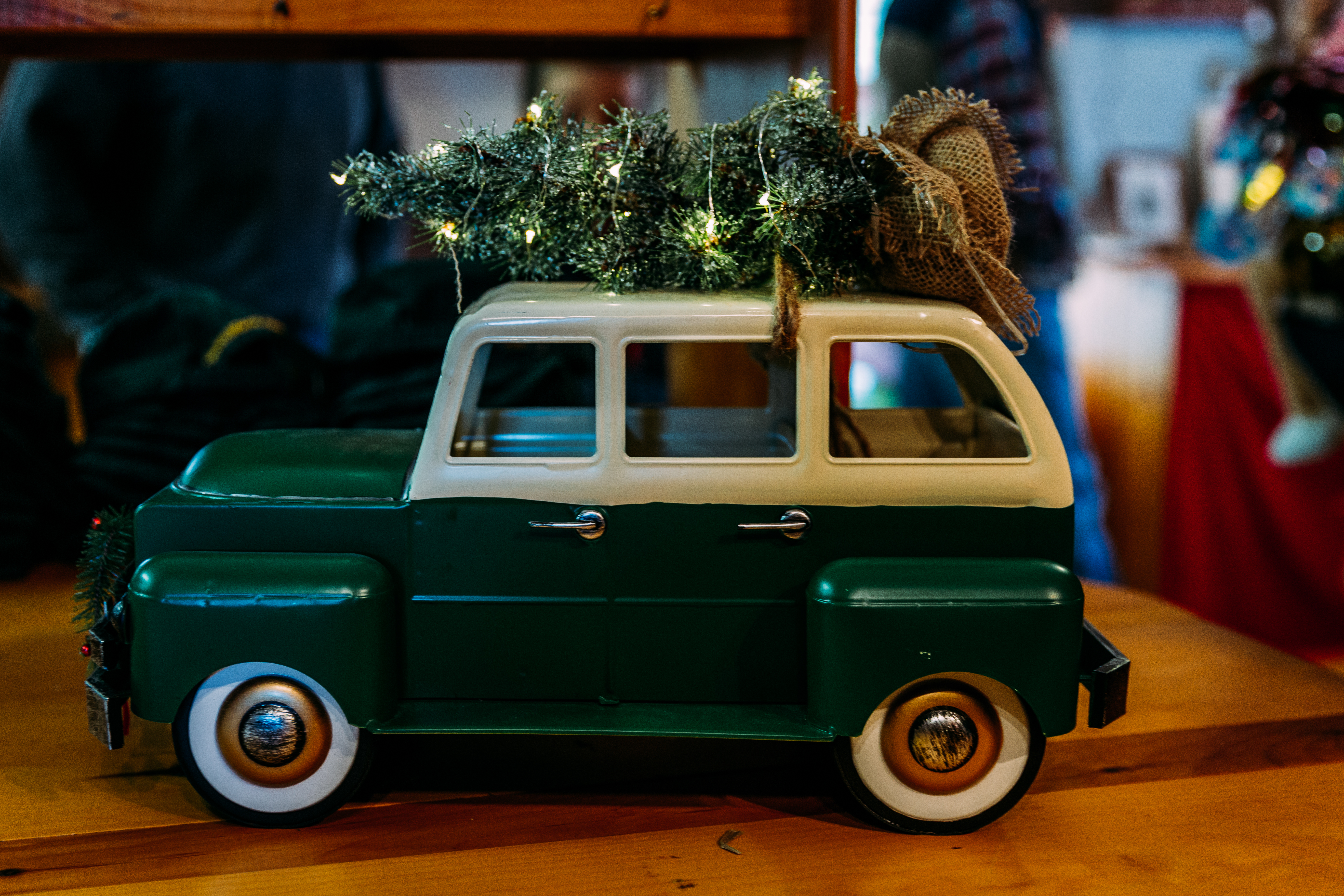 miniature green station wagon with christmas tree tied to top