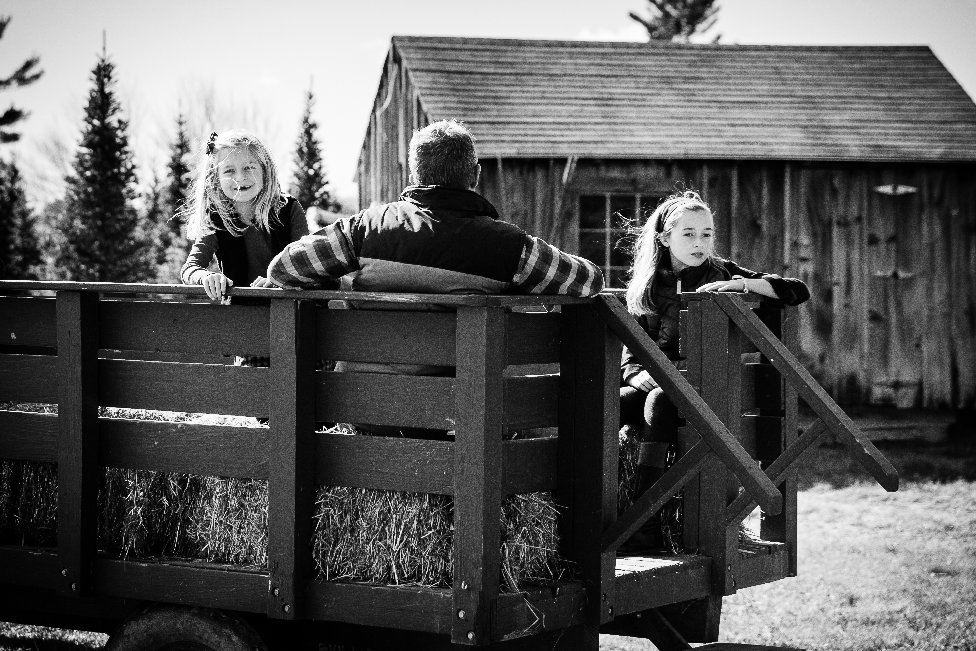 2 girls and dad sitting on tractor