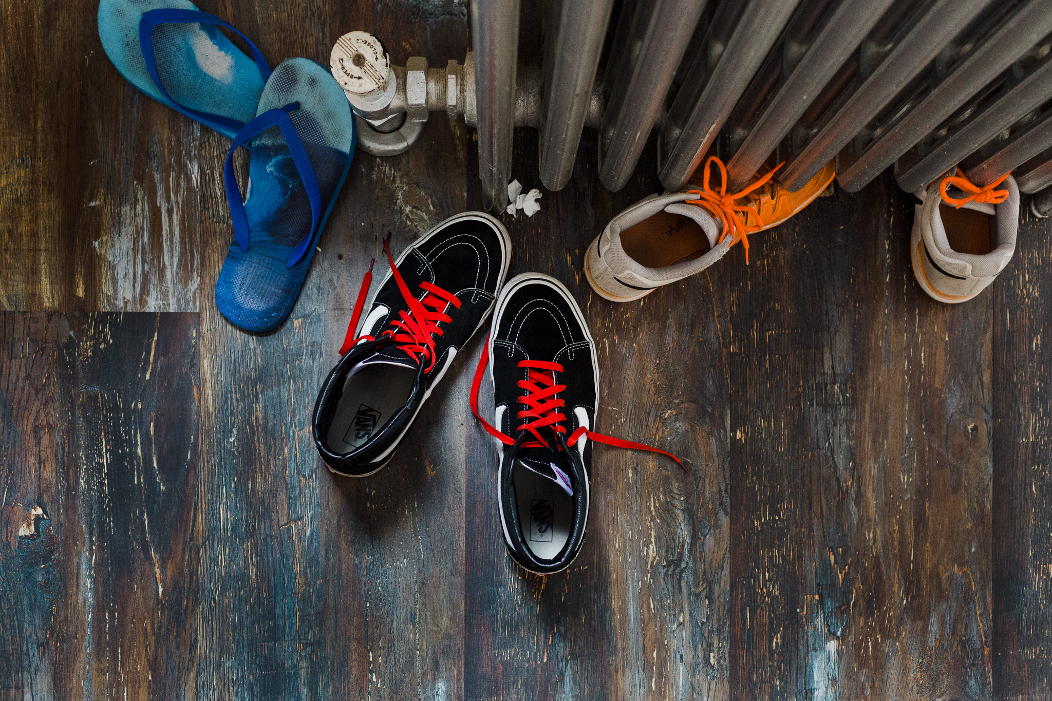 3 pairs of sneakers on a hardwood floor